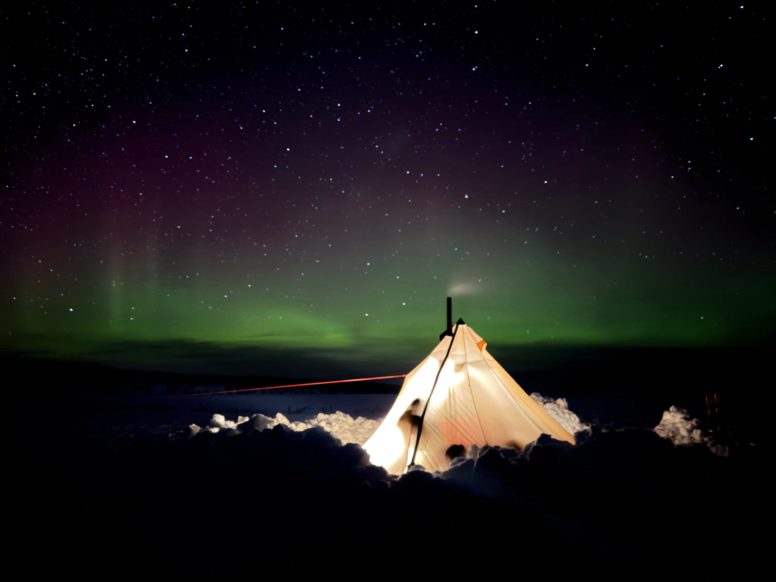 winter camping on Lake Superior beneath the northern lights