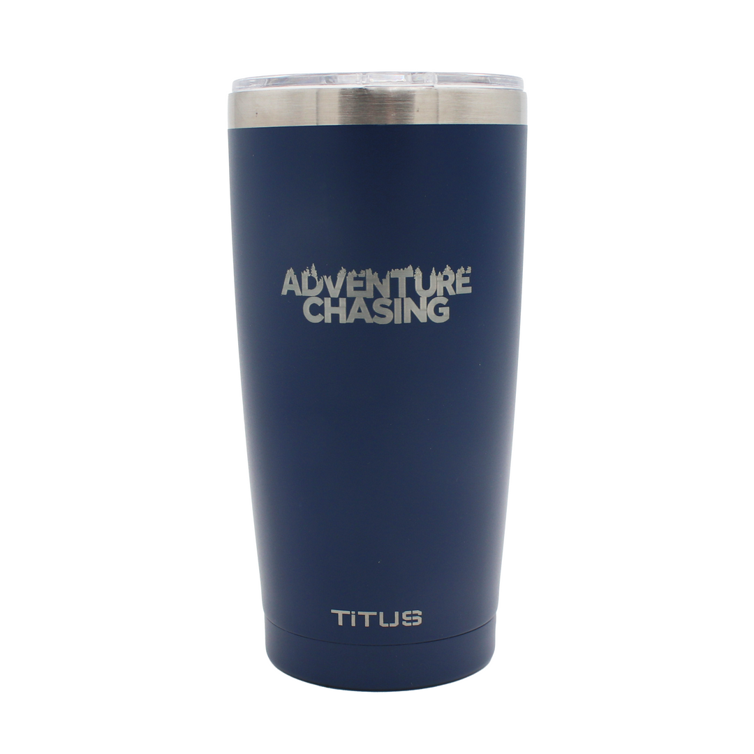 Navy blue tumbler with silver engraved 'Adventure Chasing' text and 'Titus' branding on it.