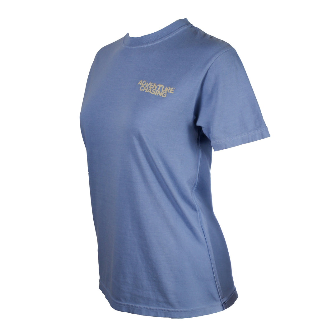 A women's short-sleeve crewneck t-shirt in a light blue color, featuring a small beige printed logo on the left chest that reads 'ADVENTURE CHASING'. 