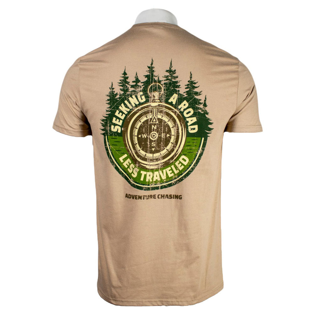 Beige t-shirt with a compass design and the text 'Seeking a road less traveled' surrounded by trees.